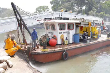TIGA BOT DIKERAHKAN: Seramai 15 pekerja daripada Singapore Oil Spill Response Centre Pte Ltd giat membersihkan pencemaran minyak di kawasan Terminal Feri Changi Point, semalam. - Foto FARAH REZAL