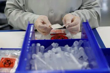 Seorang teknisyen sedang memasang kit ujian koronavirus di Fremont, Amerika pada 26 Mac 2020. 