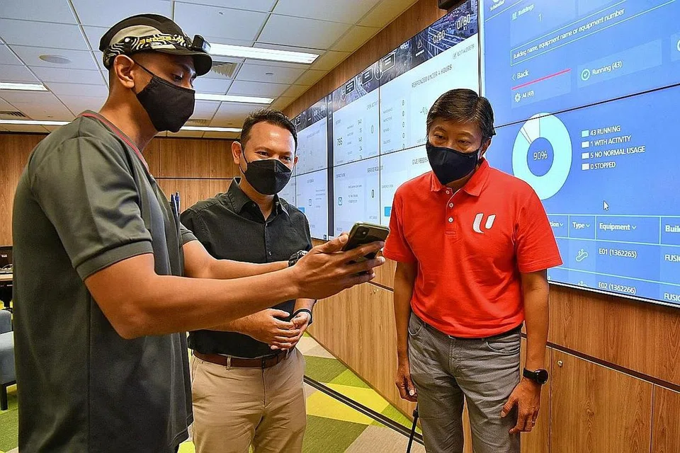 TINGKATKAN PEKERJA: (Dari kiri) Seorang teknisyen Schindler Lifts, Encik Abdul Razak Abd Rahman, menunjukkan Encik Zaqy dan Encik Ng Chee Meng, Setiausaha Agung NTUC, sebuah aplikasi yang membantu dalam tugasannya. - Foto BH oleh CHONG JUN LIANG