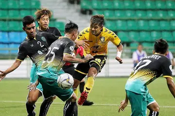 DIKAWAL KETAT: Amri (jersi kuning) dikawal ketat oleh pemain Yangon United, namun pemain Tampines itu tetap berjaya menjaringkan hatrik dalam memastikan kemenangan 4-3 Rabu lalu. - Foto BH oleh GAVIN FOO