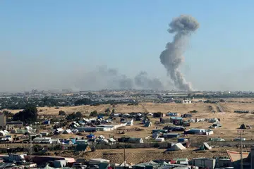 Asap berkepulan semasa operasi darat Israel di Khan Younis, di tengah-tengah konflik berterusan antara Israel dengan Hamas, seperti yang dilihat dari kem yang melindungi penduduk Palestin yang kehilangan tempat tinggal di Rafah, selatan Jaluran  Gaza, pada 11 Februari. 