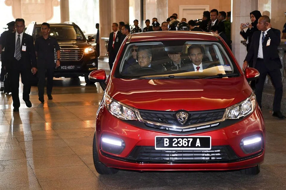 MEMANDU KERETA UNTUK PELAWAT NEGARA: Perdana Menteri Tun Dr Mahathir Mohamad memandu Kereta Proton Persona untuk membawa Presiden Indonesia Joko Widodo ke jamuan tengahari (9 Ogos). -Foto: ST.