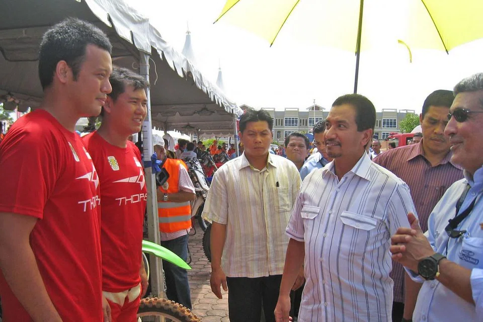 SUKAN LASAK: Gambar atas pula menunjukkan Amin dan rakan sepasukan, Kwok Wing Kit (kededuanya berpakaian merah), berbual dengan Agong Malaysia ketika itu, Sultan Mizan Zainal Abidin, sebelum perlumbaan FIM Asia 2011. - Foto ihsan MUHAMMAD AMIN KHALID