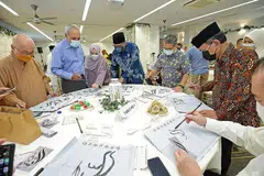 HUBUNGAN ERAT: Menteri Kebudayaan, Masyarakat dan Belia merangkap Menteri Kedua Undang-Undang, Encik Edwin Tong (lima dari kiri), kelihatan sedang melakukan aktiviti tulisan kaligrafi Islam Cina semasa majlis Perjumpaan Hari Raya antara agama bersama Ketua Eksekutif Majlis Ugama Islam Singapura (Muis), Encik Kadir Maideen (empat dari kiri) dan Presiden Muis, Encik Saat A. Rahman (dua dari kanan). - Foto MUIS
