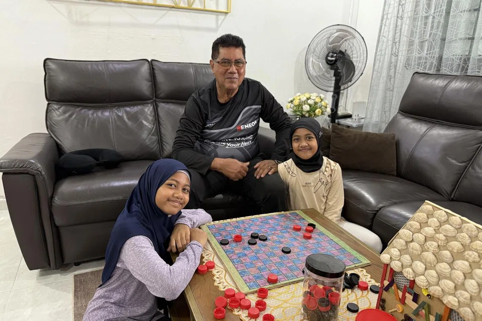 Encik Muhammad Ya’kob Ameer Ali suka bermain permainan kampung dengan cucu-cucunya, Azeen Ayeesha Mohamed Miftah (kiri) dan Ayra Eiliyah Mohamed Miftah (kanan).