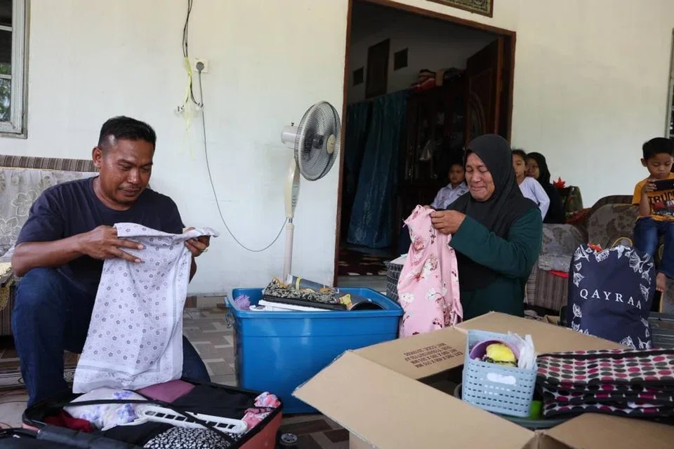 Cik Norinda Kasim (kanan) dan suaminya tidak dapat menahan sebak apabila hanya mampu melihat baju kepunyaan Allahyarhamha Nur Dalila Farhana Mohamad Isma, selepas anaknya sulungnya itu maut dalam kemalangan melibatkan bas di Jalan Raya Timur-Barat (JRTB) berhampiran Tasik Banding, Gerik di Perak pada 9 Jun.