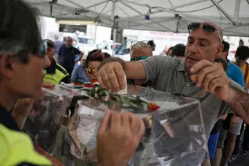 HULUR DERMA: Orang ramai menghulurkan derma bagi mangsa gempa dalam sebuah majlis amal di Piazza San Carlo di Turin kelmarin. Gempa sekuat 6.2 magnitud telah melanda tiga bandar di Italy dan membunuh 290 penduduk. - Foto AFP