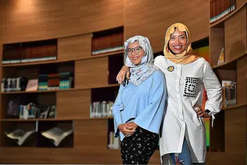 MELALUI CABARAN BERSAMA: Dr Elly Sabrina Ismail (kanan) bersama anaknya, Anastasia Sabrina Zuraimi, yang mempunyai autisme. Dr Elly banyak memberi bimbingan kepada anaknya itu tentang kemahiran interaksi sosial kerana hal tersebut tidak datang secara semula jadi kepada Anastasia. - Foto BH oleh LIM YAOHUI