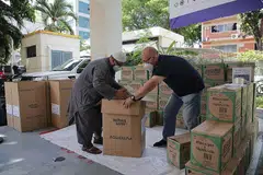 BANTUAN KEMANUSIAAN KRISIS DI GAZA: Ustaz Muslim Ahmad (kiri) dan Encik Dennis Khoo antara relawan yang turun padang menyiapkan bekalan bagi bantuan kemanusiaan di Gaza semalam. - Foto BH oleh GIN TAY