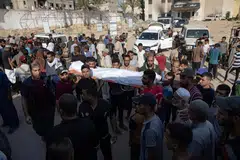 Penduduk Palestin mengusung jenazah saudara mereka yang terkorban dalam serangan Israel ke atas Hospital Nasser di Khan Yunis, di selatan Jaluran Gaza, pada 12 Ogos. 