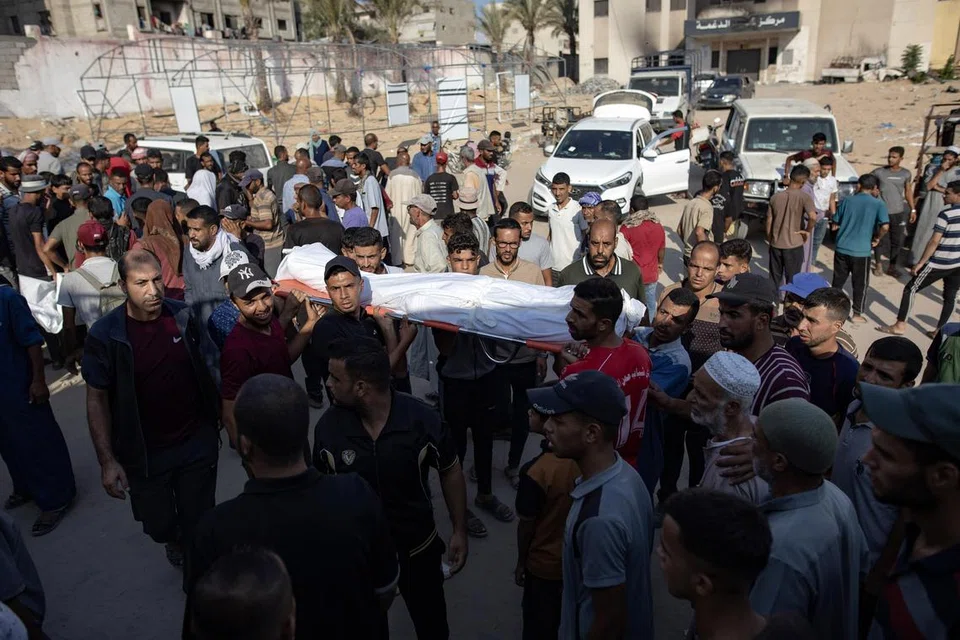Penduduk Palestin mengusung jenazah saudara mereka yang terkorban dalam serangan Israel ke atas Hospital Nasser di Khan Yunis, di selatan Jaluran Gaza, pada 12 Ogos. 