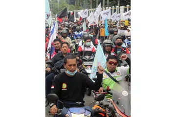BUAT BANTAHAN: Pekerja 'berarak' dengan motosikal mereka bagi membantah kelulusan undang-undang pekerjaan dekat pejabat kementerian tenaga kerja di Jakarta. - Foto EPA-EFE.