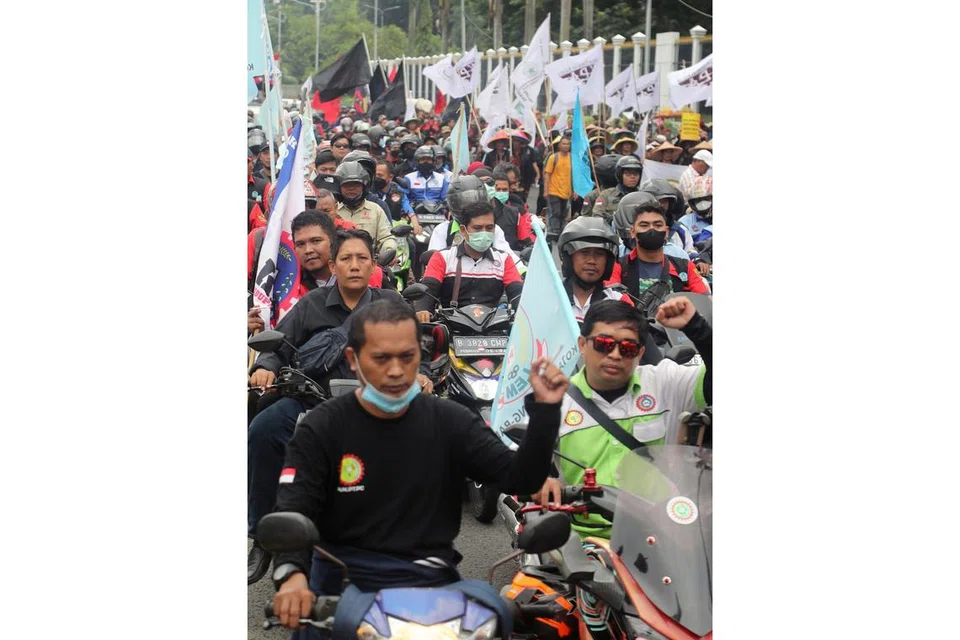 BUAT BANTAHAN: Pekerja 'berarak' dengan motosikal mereka bagi membantah kelulusan undang-undang pekerjaan dekat pejabat kementerian tenaga kerja di Jakarta. - Foto EPA-EFE.