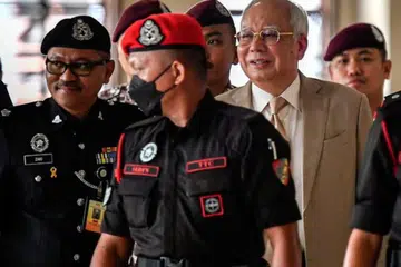 Mantan Perdana Menteri Malaysia, Encik Najib Tun Razak (belakang kanan) hadir perbicaraan bagi membela diri terhadap empat tuduhan menggunakan kedudukan bagi peroleh suapan berjumlah RM2.3 bilion dana 1Malaysia Development Berhad (1MDB) dan 21 tuduhan pengubahan wang haram, pada 4 Disember.