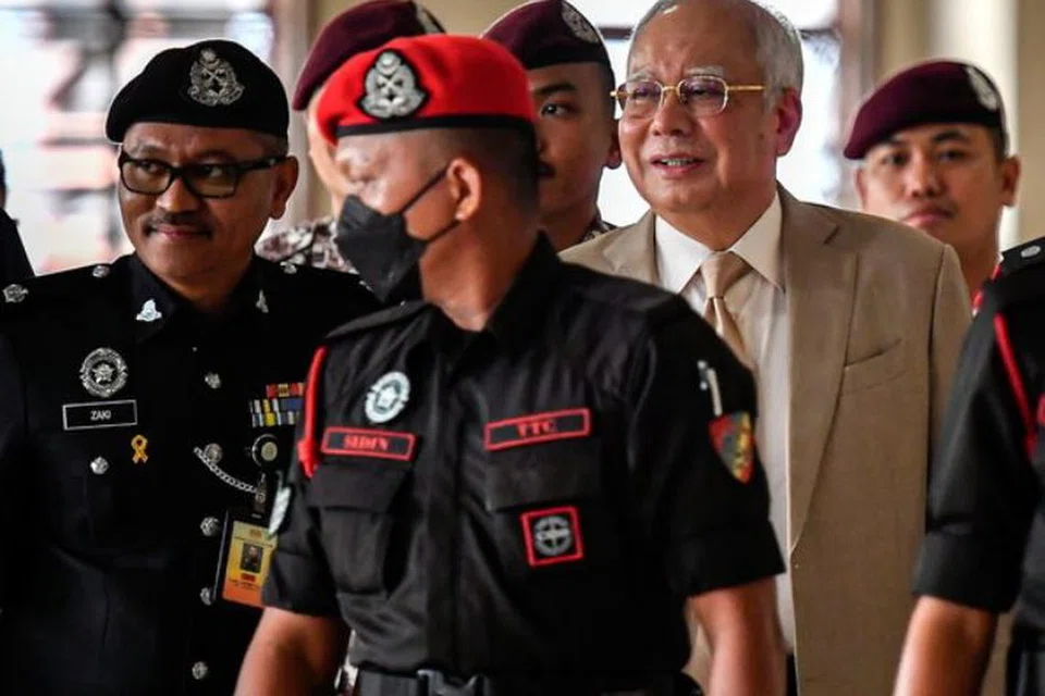 Mantan Perdana Menteri Malaysia, Encik Najib Tun Razak (belakang kanan) hadir perbicaraan bagi membela diri terhadap empat tuduhan menggunakan kedudukan bagi peroleh suapan berjumlah RM2.3 bilion dana 1Malaysia Development Berhad (1MDB) dan 21 tuduhan pengubahan wang haram, pada 4 Disember.