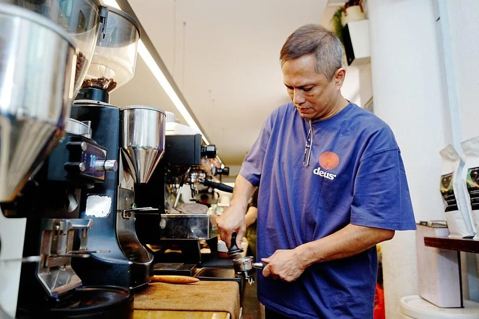 Encik Mustafah membuat kopi untuk pelanggannya. 