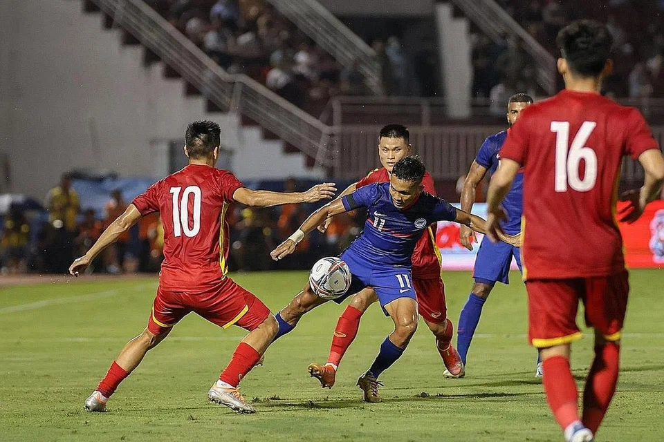 PERLU PERTINGKAT PERMAINAN: Pemain Singapura Hafiz Nor (tengah, jersi biru) cuba melepasi pemain Vietnam dalam perlawanan persahabatan di Stadium Thong Nhat di Ho Chi Minh malam kelmarin. Jurulatih Nishigaya kecewa Singa kalah tetapi berpuas hati akan persembahan wajah-wajah baru pasukannya, terutama Joshua Pereira. - Foto-foto PERSATUAN BOLA SEPAK SINGAPURA