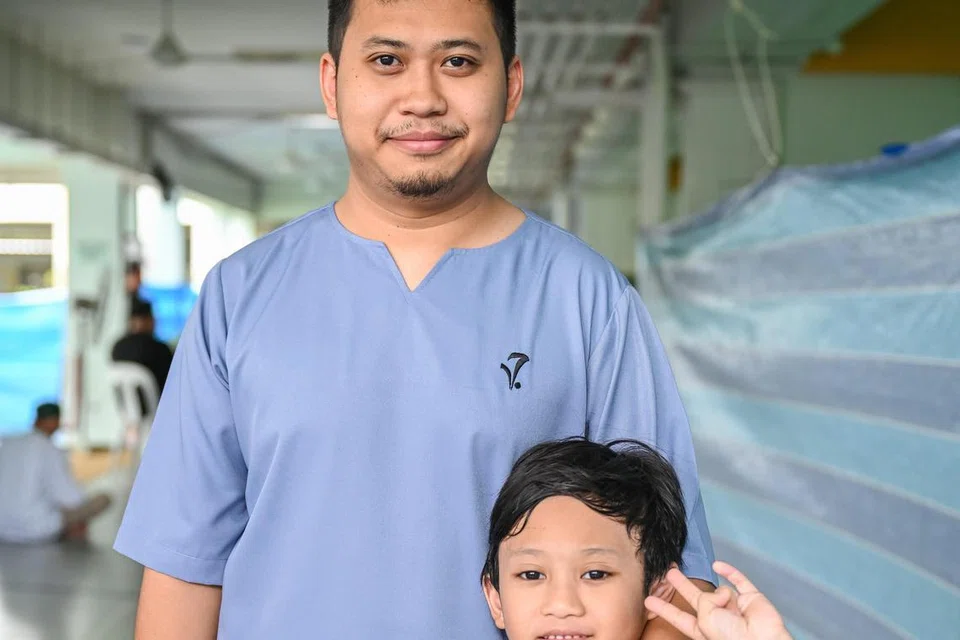 Encik Hakim Normin bersama anaknya, Luqman Mikhael, tujuh tahun, ketika menunaikan solat Jumaat yang diadakan buat kali terakhir di tapak sementara Masjid Darul Makmur pada 6 Jun. 