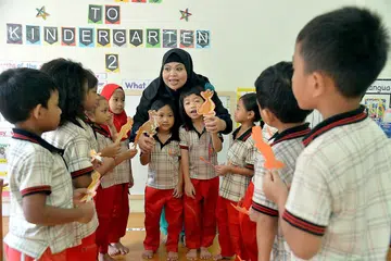 TINGKAT MUTU GURU: Cik Norizan Rahmat, yang bersama muridnya di Pusat Pendidikan Awal Kanak-Kanak PPIS di Jurong, mengalu-alukan penubuhan Institut Nasional Pembangunan Awal Kanak-Kanak (NIEC) kerana yakin ia akan mempertingkat tahap profesional guru prasekolah sepertinya. - Foto M.O. SALLEH