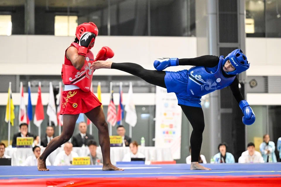 Atlet wushu Singapura, Siti Khadijah Mohamad Shahrem (ves biru), menentang atlet Myanmar, Hnin Nu Wah di separuh akhir acara sanda (tanding) wushu 60 kilogram.
