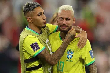 KECEWA: Neymar (kanan), yang menitiskan air mata selepas Brazil terkandas dalam suku akhir semalam, dipujuk rakan sepasukan, Raphinha - Foto AFP