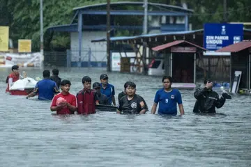 Penduduk di Pengkalan Chepa, Kelantan, keluar dari kawasan banjir pada 23 November. 
