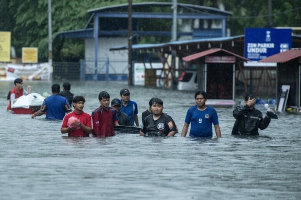 Penduduk di Pengkalan Chepa, Kelantan, keluar dari kawasan banjir pada 23 November. 