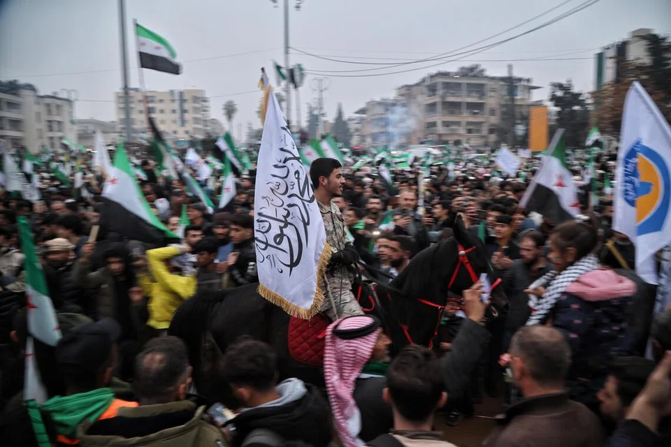 Orang ramai berkumpul ketika perarakan bagi memperingati ulang tahun pertama penyingkiran rejim Bashar al-Assad, di Idlib, Syria, pada 8 Disember 2025. Syria mengenang ulang tahun pertama kejatuhan rejim Assad pada 8 Disember, apabila pemerintahan diktator Encik Assad runtuh susulan ofensif besar oleh pasukan pembangkang.