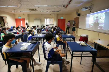 DI BILIK DARJAH: Para pelajar Sekolah Rendah Qihua menyertai lawatan alam maya Masjid Sultan dengan menggunakan peralatan robot mudah alih dari keselesaan bilik darjah mereka. - Foto ZAOBAO