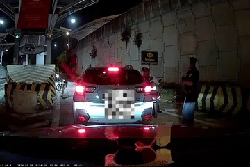 Tangkap layar video menunjukkan dua anggota polis trafik Bangunan Sultan Iskandar (BSI) yang didakwa memeras ugut pasangan warga Singapura RM500 kerana memasuki lorong salah untuk pulang ke Singapura.