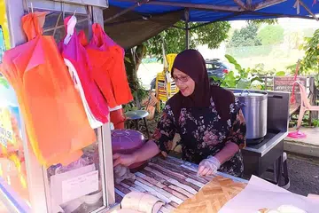 TERPAKSA NAIKKAN HARGA JUALAN: Cik Jamaliah terpaksa menaikkan harga nasi ayam disebabkan kenaikan harga ayam segar. - Foto-Foto BM oleh KHIRUL BAHRI BASARUDDIN
