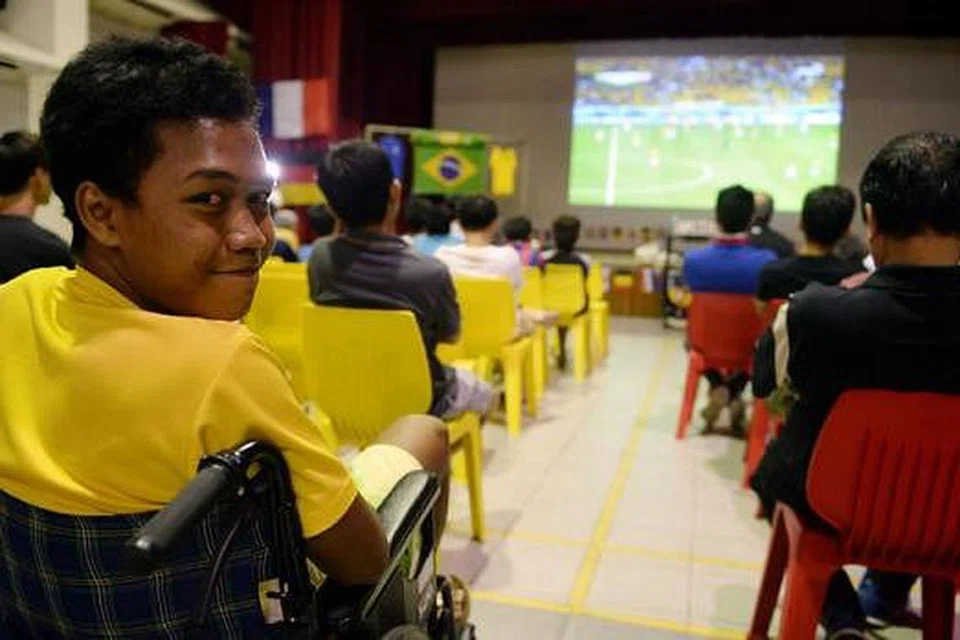 SELESA: Akibat cedera di kaki, Muhammad Ghilmaan terpaksa menggunakan kerusi roda namun dapat menonton perlawanan dengan selesa di dewan serba guna Kelab Masyarakat Tampines West.