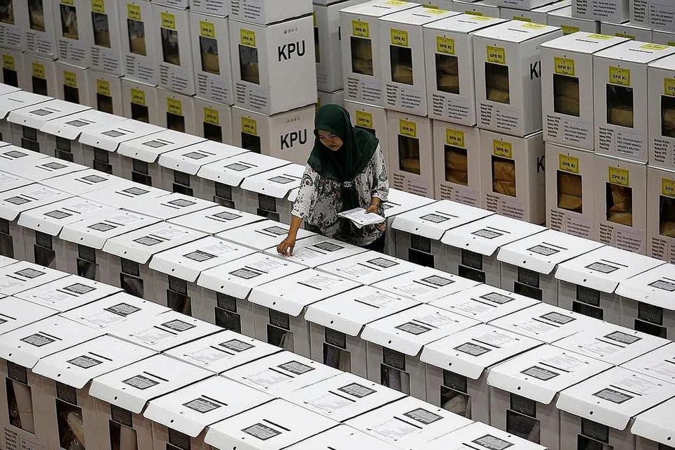 HANYA TUNGGU MASA: Seorang pegawai membuat persiapan akhir di sebuah gudang di Jakarta sebelum kotak undi diedarkan di pusat mengundi. - Foto REUTERS