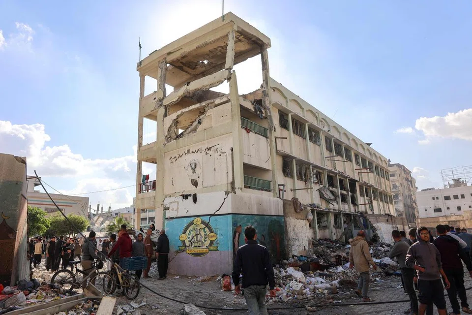 Penduduk memeriksa kerosakan selepas serangan Israel ke atas Sekolah Pentadbiran UNWRA Al-Majda Wasila yang menempatkan pelarian Palestin, di Jalan al-Jalaa, Bandar Gaza, pada 14 Disember.