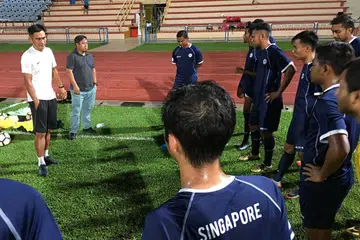 PERSIAP PASUKAN: Bekas kapten Singapura yang kini penolong jurulatih Singa Muda (Young Lions), Nazri Nasir (kiri), memberikan kata-kata semangat kepada pasukannya yang akan beraksi dalam Piala Emas Raja-Raja tahun ini. Berdiri di kiri Nazri ialah penolong pengurus pasukan, Nasirruddin Sawardi. - Foto BH oleh FAKHRURADZI ISMAIL