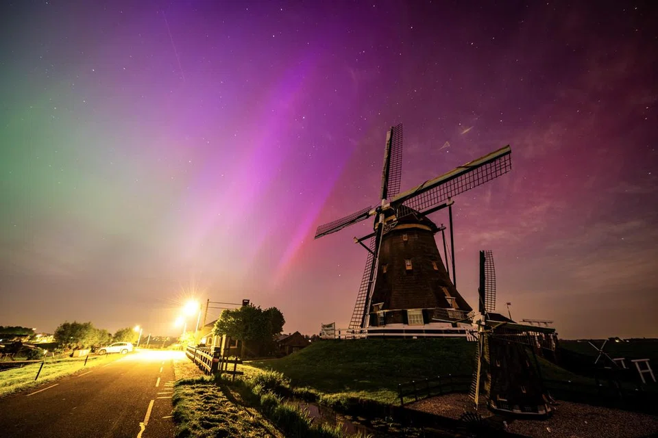Pertunjukan aurora, cahaya cakerawala yang menakjubkan, mewarnai langit malam di Molenviergang di Aarlanderveen, Belanda, pada 11 Mei.