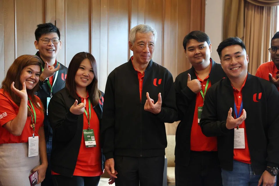 
Perdana Menteri, Encik Lee Hsien Loong (tengah), bersama pemimpin belia di Persidangan Perwakilan Kebangsaan NTUC 2023, termasuk Cik Nur Akidah Ramad (kiri) yang merupakan Ahli Ganti, Jawatankuasa Muda NTUC. 