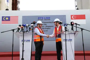 SIDANG MEDIA: Pemangku Menteri Pengangkutan Singapura, Encik Chee Hong Tat (kanan) dan Menteri Pengangkutan Malaysia, Encik Anthony Loke, berjabat tangan setelah sidang media di mana mereka menjawab soalan daripada media Singapura dan Malaysia mengenai projek Laluan Sistem Transit Laju (RTS Link) Johor Bahru-Singapura pada 11 Januari di tapak RTS Link Marine Viaduct di Selat Johor.