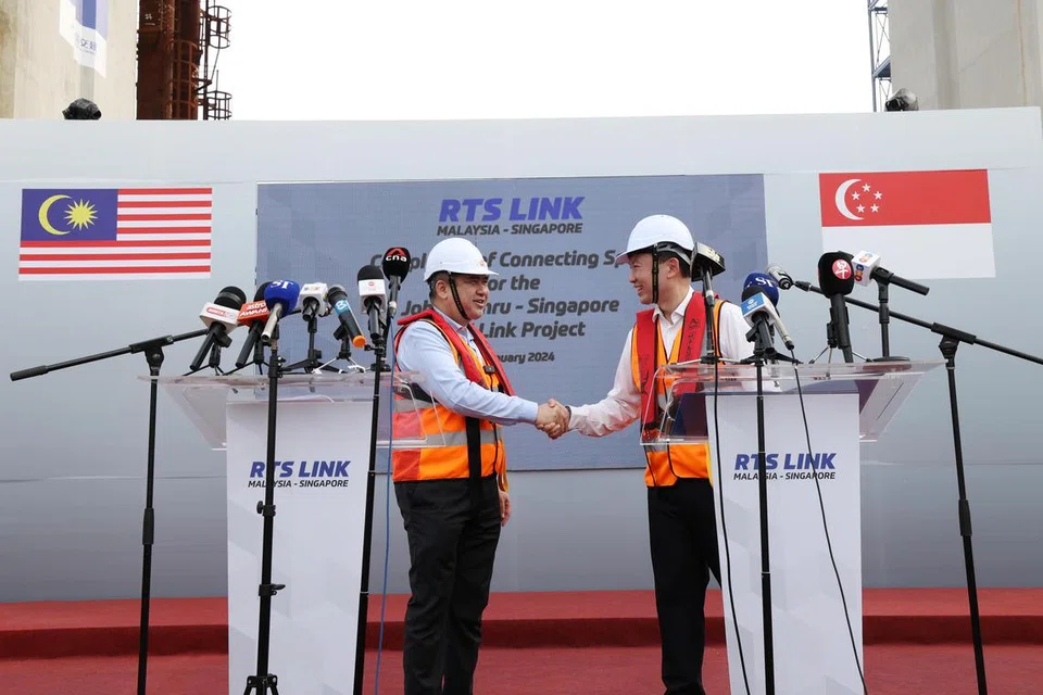 SIDANG MEDIA: Pemangku Menteri Pengangkutan Singapura, Encik Chee Hong Tat (kanan) dan Menteri Pengangkutan Malaysia, Encik Anthony Loke, berjabat tangan setelah sidang media di mana mereka menjawab soalan daripada media Singapura dan Malaysia mengenai projek Laluan Sistem Transit Laju (RTS Link) Johor Bahru-Singapura pada 11 Januari di tapak RTS Link Marine Viaduct di Selat Johor.