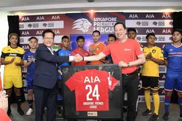 PENAJA BARU: Encik Lim Kia Tong (depan, kiri) dan Encik Patrick Teow berjabat tangan selepas menandatangani perjanjian penajaan baru bagi musim Liga Perdana Singapura selama dua tahun.