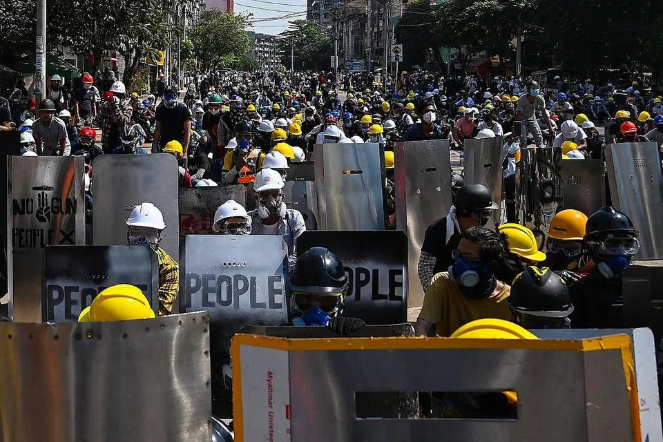 TERUS BANTAH: Penunjuk perasaan yang menggunakan perisai buatan sendiri terus mengadakan bantahan dan menghadapi pasukan keselamatan Myanmar dalam satu bantahan di Yangon kelmarin. - Foto AFP