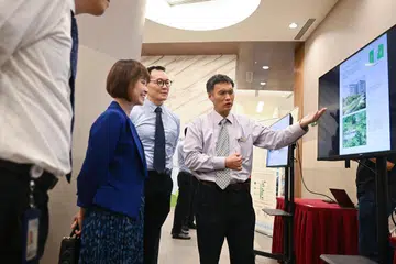 Pengarah Perancangan Prasarana dan Hospital, Yishun Health, Encik Donald Wai (kanan), memberi taklimat kepada Menteri Negara Kanan (Kemampanan dan Sekitaran merangkap Pengangkutan), Dr Amy Khor, sewaktu Simposium Kemampanan Jagaan Kesihatan Awam di Hospital Ng Teng Fong pada 22 April.