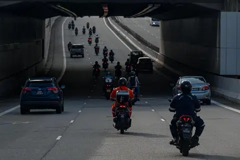  Encik Mohd Aminurashid Ali Akbar menunggang motosikalnya untuk ke tempat kerja di Singapura.
