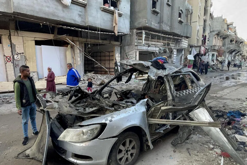 Para penduduk melihat sebuah kereta yang musnah bersama tiga anak lelaki pemimpin kanan Hamas, Encik Ismail Haniyeh, yang terbunuh akibat serangan udara Israel di kem pelarian Al-Shati di barat Gaza pada 10 April.
