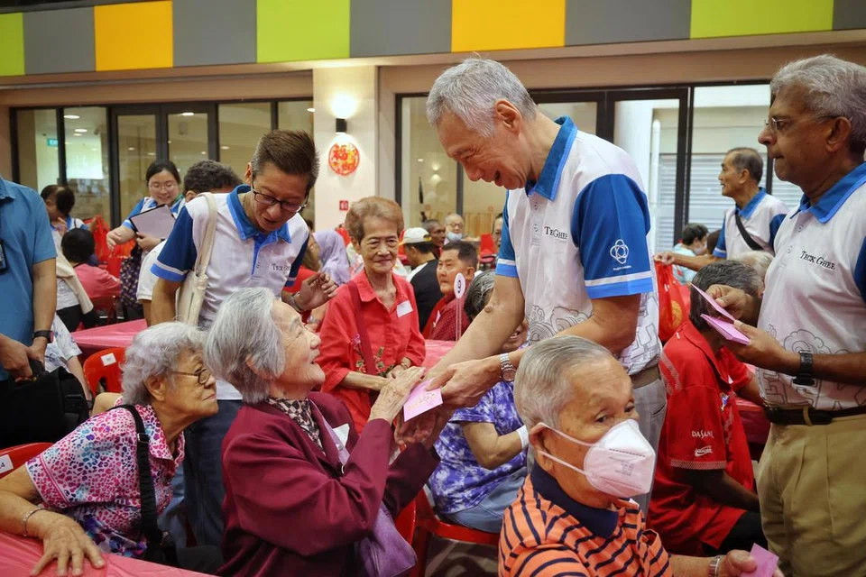 Lebih daripada 400 warga emas berpendapatan rendah yang berkumpul di CC Teck Ghee mulai 8 pagi untuk menerima hongbao daripada Menteri Kanan, Encik Lee Hsien Loong (berdiri, dua dari kanan), meskipun hujan turun dengan lebat. 
