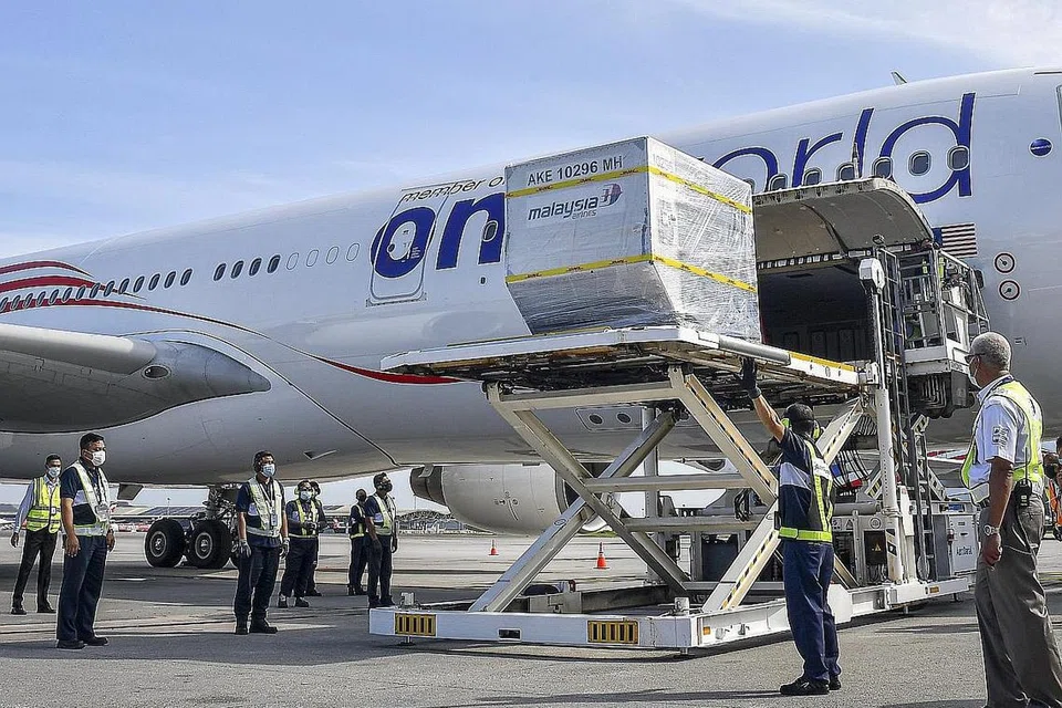 KUMPULAN VAKSIN PERTAMA: Pesawat membawa bekalan vaksin Covid-19 Pfizer-BioNTech tiba di Lapangan Terbang Antarabangsa Kuala Lumpur (KLIA) semalam. - Foto EPA-EFE