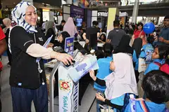 Penolong Pengurus Audiens dan Perkembangan BH, Cik Ismawati Ismail, mengagihkan akhbar Cilik Cerdik terbitan BH kepada kanak-kanak yang berkunjung ke reruai BH di Our Tampines Hub pada 12 Julai.
