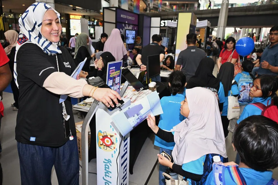 Penolong Pengurus Audiens dan Perkembangan BH, Cik Ismawati Ismail, mengagihkan akhbar Cilik Cerdik terbitan BH kepada kanak-kanak yang berkunjung ke reruai BH di Our Tampines Hub pada 12 Julai.