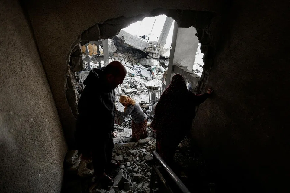Penduduk Palestin memeriksa kemusnahan pada bangunan akibat pengeboman Israel di Rafah, selatan Gaza, pada 24 Mac.