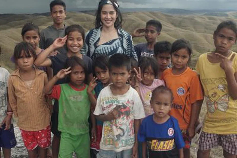 Pelakon Indonesia, Dian Sastrowardoyo (tengah) bersama kanak-kanak yang meraih manfaat hasil daripada projek kebajikannya di Indonesia.